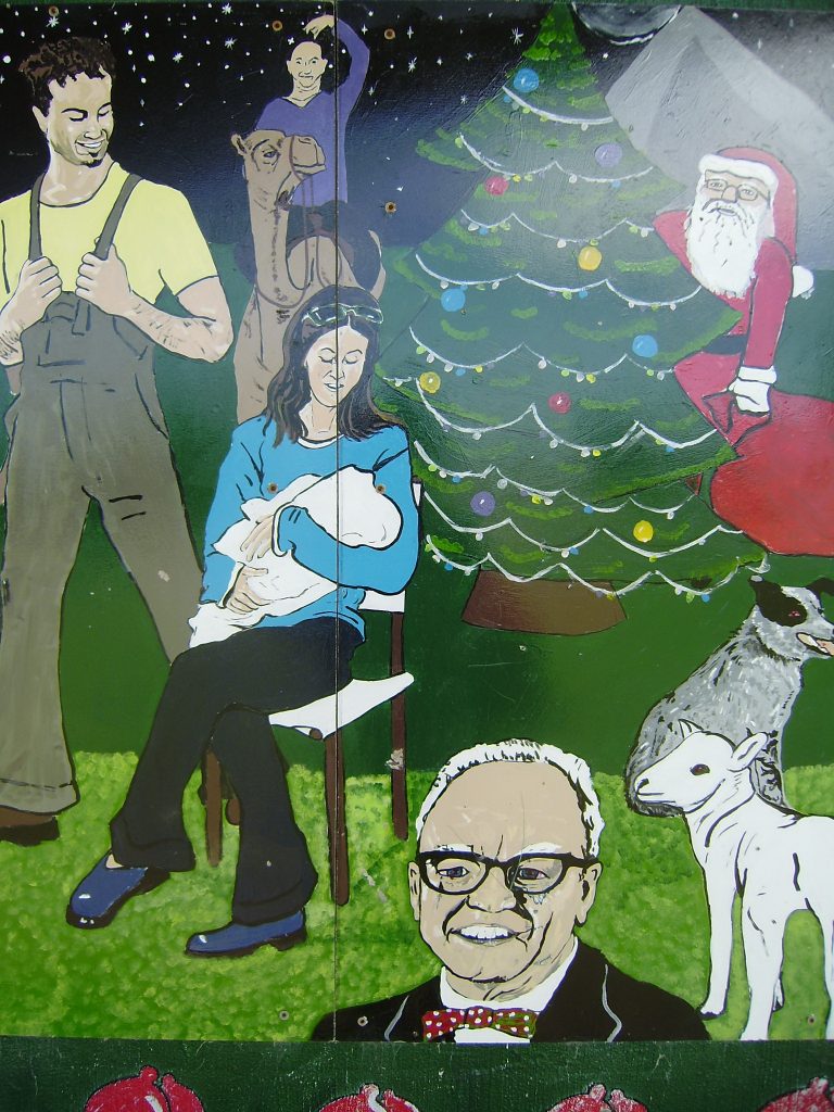 Santa hide sbehind the tree of proud parents; Grampa in the way, again.